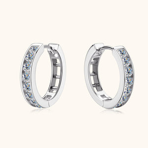 A pair of gold-colored hoop earrings with blue moissanite gemstones set within the hoops.