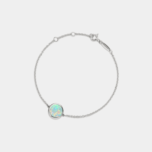 A white gold-plated sterling silver bracelet featuring a small round opal locket with an adjustable chain.