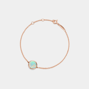 A rose gold-plated sterling silver bracelet featuring a small round opal locket with an adjustable chain.