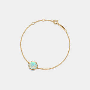 A gold-plated sterling silver bracelet featuring a small round opal locket with an adjustable chain.