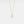 Gold necklace with a pendant featuring an opal stone on a light gray background