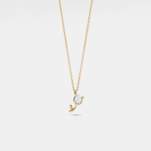 Gold necklace with a pendant featuring an opal stone on a light gray background