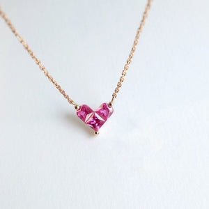 Three small heart-shaped pendant necklaces on gold-plated chains, displayed against a white background.