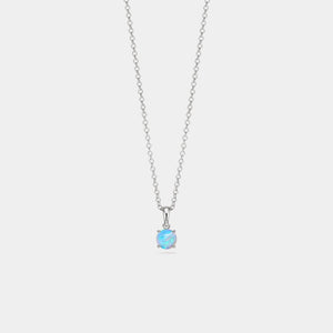 Silver necklace with a round blue gemstone on a light gray background
