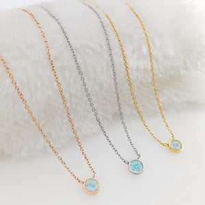 Three necklaces with pendant stones on a textured white surface