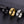 Three rings in black, gold, and silver on a dark textured surface