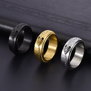 Three rings in black, gold, and silver on a dark textured surface