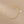 Gold necklace with a heart-shaped pendant on a beige background