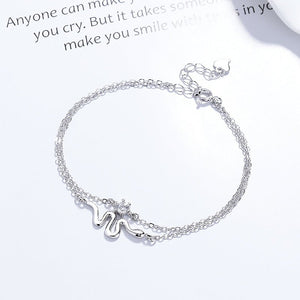 Silver bracelet with a star charm on a light gray background