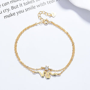 Gold bracelet with chain and letter 'M' charm on a white background