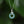 Necklace with a green pendant and silver snake design on a blurred green background