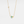 Gold necklace with a star and opal pendant on a light gray background