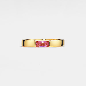 Gold ring with a pink gemstone on a light gray background
