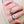 Close-up of a hand wearing two diamond stud earrings on a neutral background