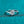 Silver ring with a diamond on a teal glittery background