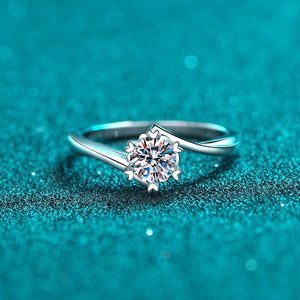 Silver ring with a diamond on a teal glittery background