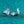 Silver stud earrings with a clear gemstone on a teal glittery background