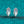 Pair of silver earrings with gemstones on a teal glittery background