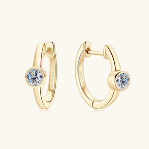 Gold hoop earrings with gemstones on a white background