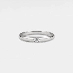 Silver ring with a small diamond on a light gray background