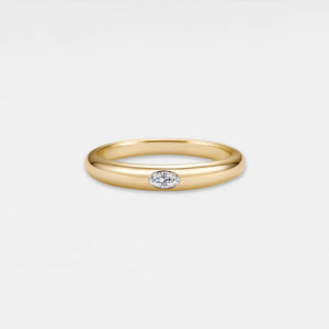 Gold ring with a small diamond on a light gray background