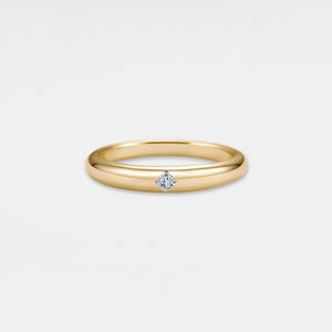 Gold ring with a diamond on a light gray background
