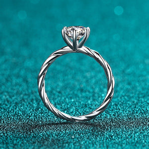 Silver ring with a diamond on a teal glitter background