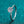 Silver ring with a diamond on a teal background