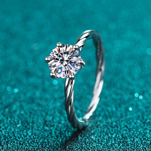 Silver ring with a diamond on a teal background