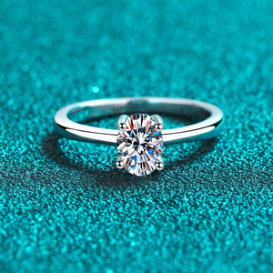 Silver ring with a diamond on a teal textured background