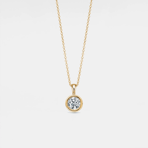 Gold necklace with a diamond pendant on a light gray background