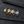 Two gold and two silver rings with gemstones on a black stone surface
