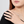 Close-up of a hand wearing multiple diamond rings on a plain background