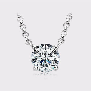 A round moissanite gemstone pendant necklace with a four-prong setting, suspended from a gold chain.