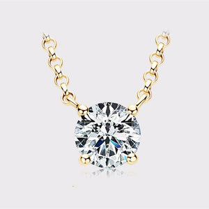 Gold necklace with a round diamond pendant on a light gray background