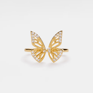 Gold butterfly ring with diamond accents on a white background