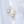 Gold earrings with clear gemstones on a light gray background