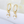 Gold hoop earrings with clear gemstones on a soft white background