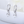 Silver hoop earrings with clear gemstones on a white surface