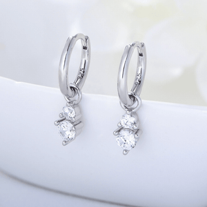 Silver hoop earrings with clear gemstones on a white surface