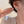 Star-shaped earrings being worn and held up to an ear against a neutral background
