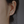 Close-up of an ear wearing a diamond stud earring with a blurred background