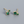 Gold earrings with green gemstones on a gray background