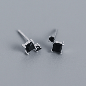 Pair of black square gemstone earrings on a gray background
