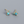 Gold earrings with turquoise stones on a gray background