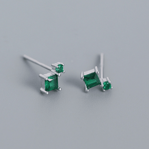 Pair of emerald green gemstone earrings on a light gray background