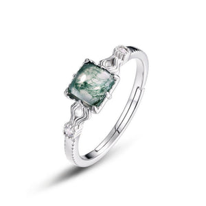 Silver ring with a green gemstone on a white background