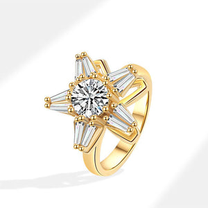 A gold-colored star-shaped fidget spinner ring with cubic zirconia stones.