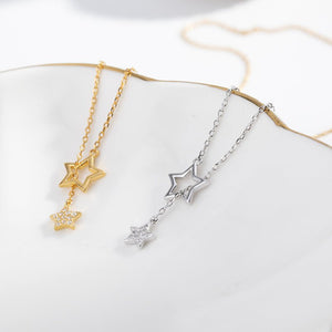 Two necklaces, one with a gold finish and the other with a silver finish, each featuring a star pendant, displayed against a white background.