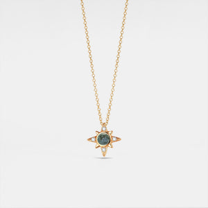 Gold necklace with a star-shaped pendant on a light gray background